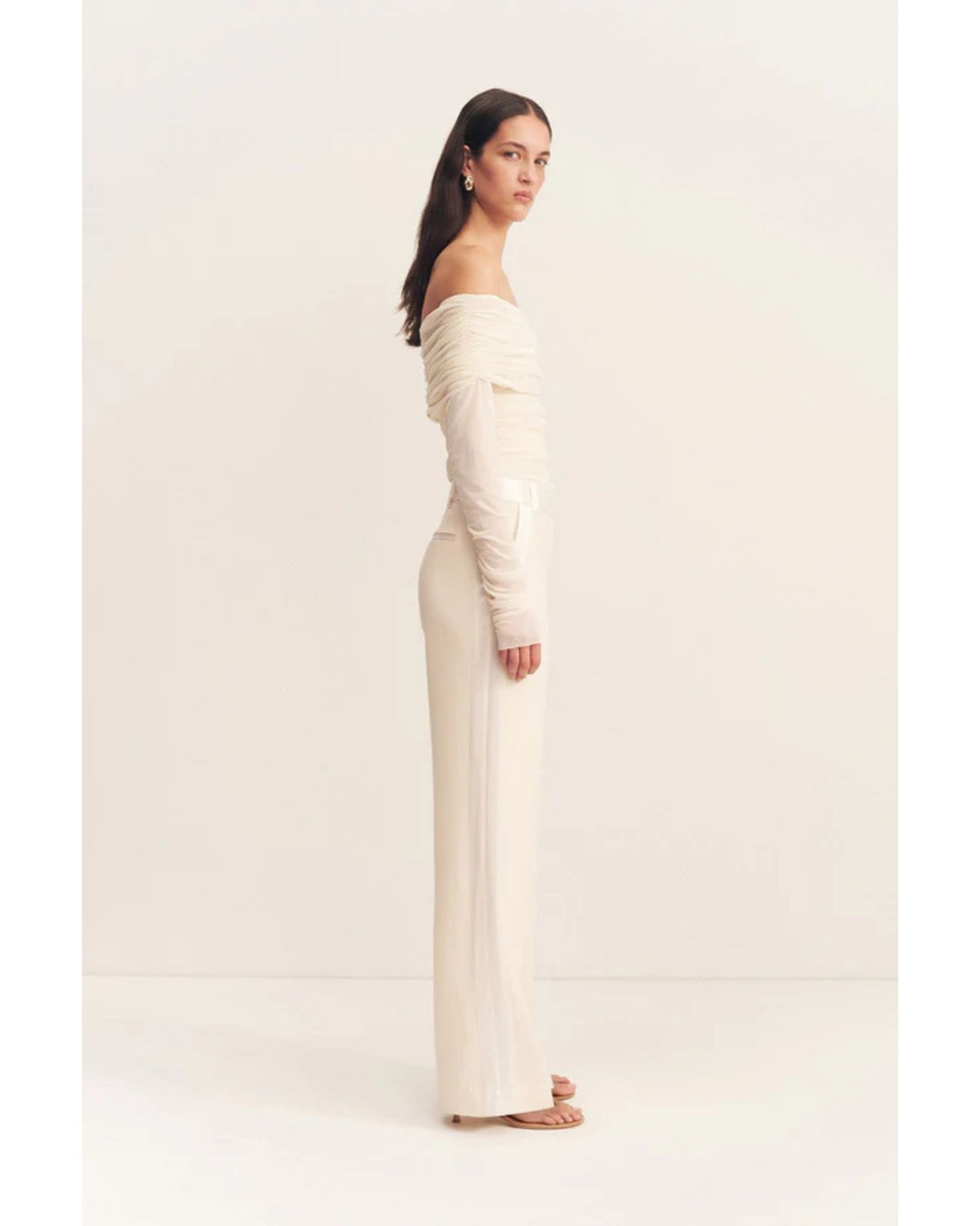 Side view, Adri Tuxedo Side Panel Pants with a contrast satin waistband, side panels, and pockets. Features include a mid-rise fit, knife pleats, jet pockets, and a relaxed straight leg. Available at Georgette bridal boutique in Brussels and online at georgettebridal.com.