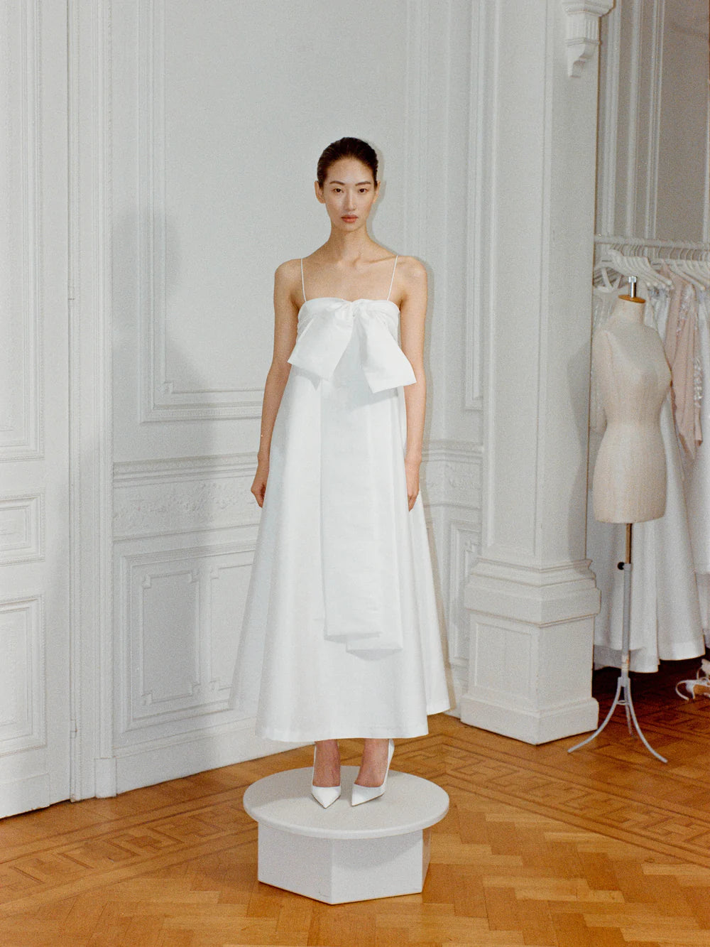 Model wearing the Bailey Wedding Dress, featuring a voluminous ankle-length taffeta skirt, a structured bustier top, and a dramatic side bow detail. Available at Georgette bridal boutique in Brussels and online at georgettebridal.com.