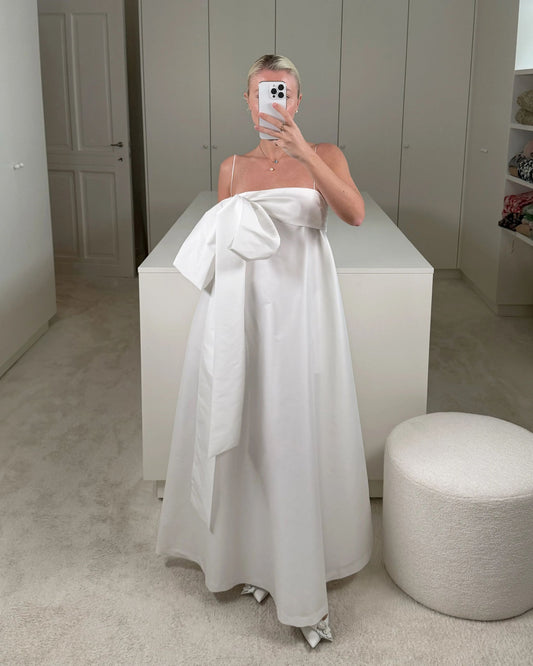 Charlotte wearing the Bailey Wedding Dress, featuring a voluminous ankle-length taffeta skirt, a structured bustier top, and a dramatic side bow detail. Available at Georgette bridal boutique in Brussels and online at georgettebridal.com.