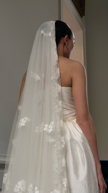 Close-up of ivory veil with delicate floral appliqué and soft tulle layers, available at Georgette bridal boutique in Brussels and online at georgettebridal.com