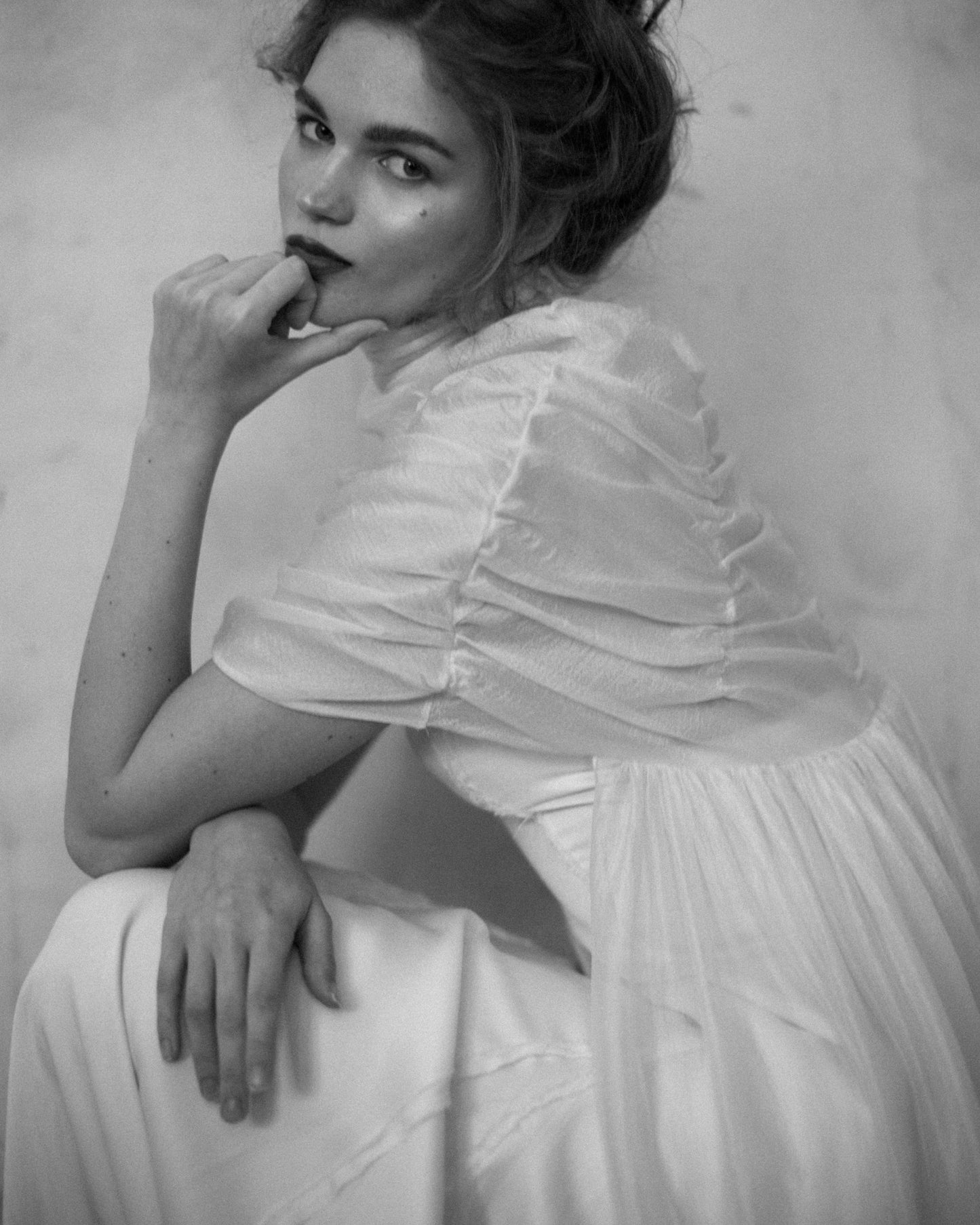 Close-up of model wearing the Elise Cape 100% Silk Tule by The Muse Collective handmade in Spain available at Georgette in Brussels and online.