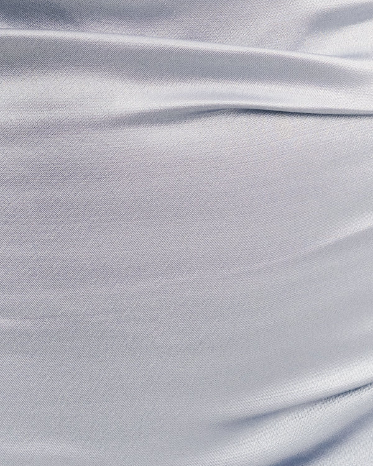 Close-up of the soft satin powder blue fabric from the La Lune One-Shoulder Dress, showing delicate ruching, available at Georgette Bridal in Brussels.
