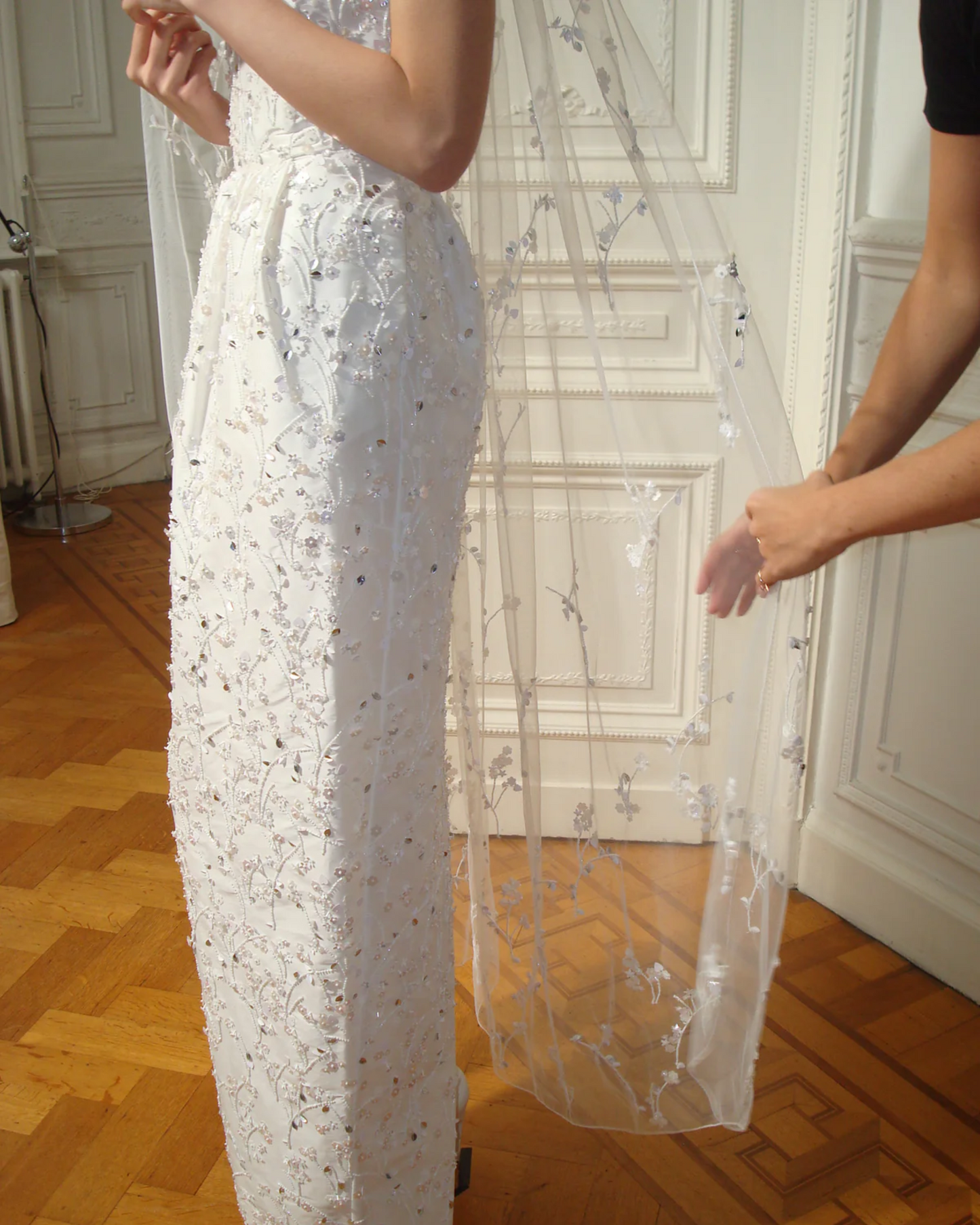 Side view of the Bernadette Little Flower veil, available at Georgette. The close-up highlights the hand-embroidered flowers and elegant drape of the ivory tulle.