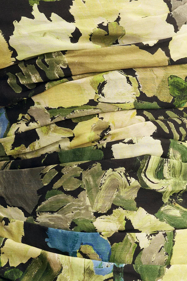 Fabric focus of a strapless tiered maxi dress in a sheer Botanical Floral print, featuring a softly draped asymmetrical bodice, full tiered skirt, and invisible side zip. Crafted from a linen and TENCEL™ blend. Available at Georgette bridal boutique in Brussels and online at georgettebridal.com.