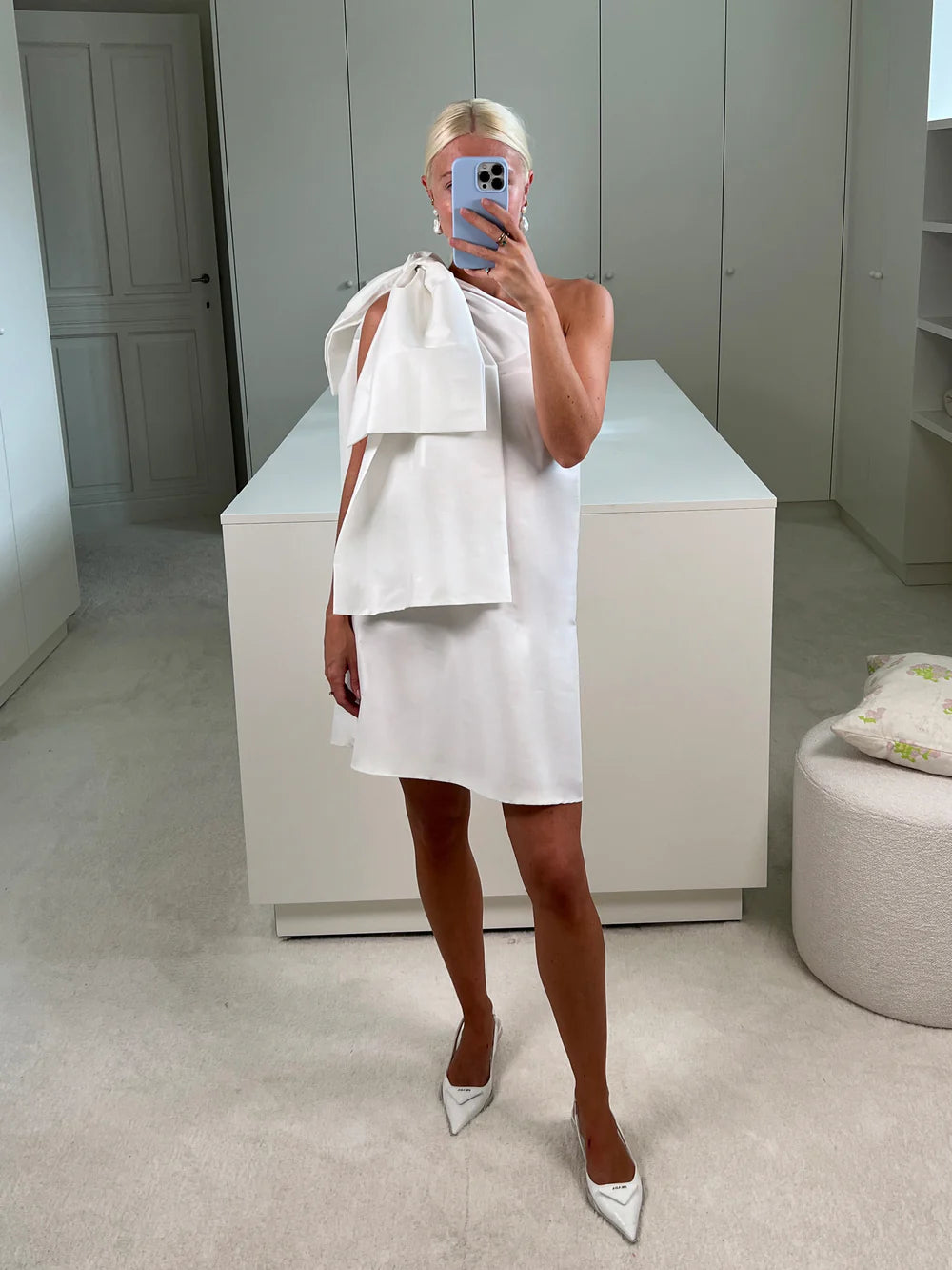 Charlotte wearing the Bernadette Winnie Short Wedding Dress in ivory taffeta, showcasing a statement bow on the left shoulder, combining modern style with timeless elegance. Available at Georgette bridal boutique in Brussels and online at georgettebridal.com.