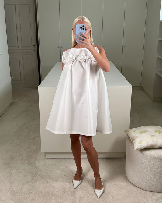 Charlotte wearing the Theodore dress from the Bernadette collection, made of crisp ivory taffeta with a sleek straight neckline decorated with delicate handmade roses, combining timeless elegance with a playful touch. Available at Georgette bridal boutique in Brussels and online at georgettebridal.com.