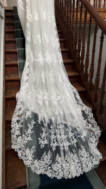 Close-up of ivory veil with delicate floral appliqué and soft tulle layers, available at Georgette bridal boutique in Brussels and online at georgettebridal.com