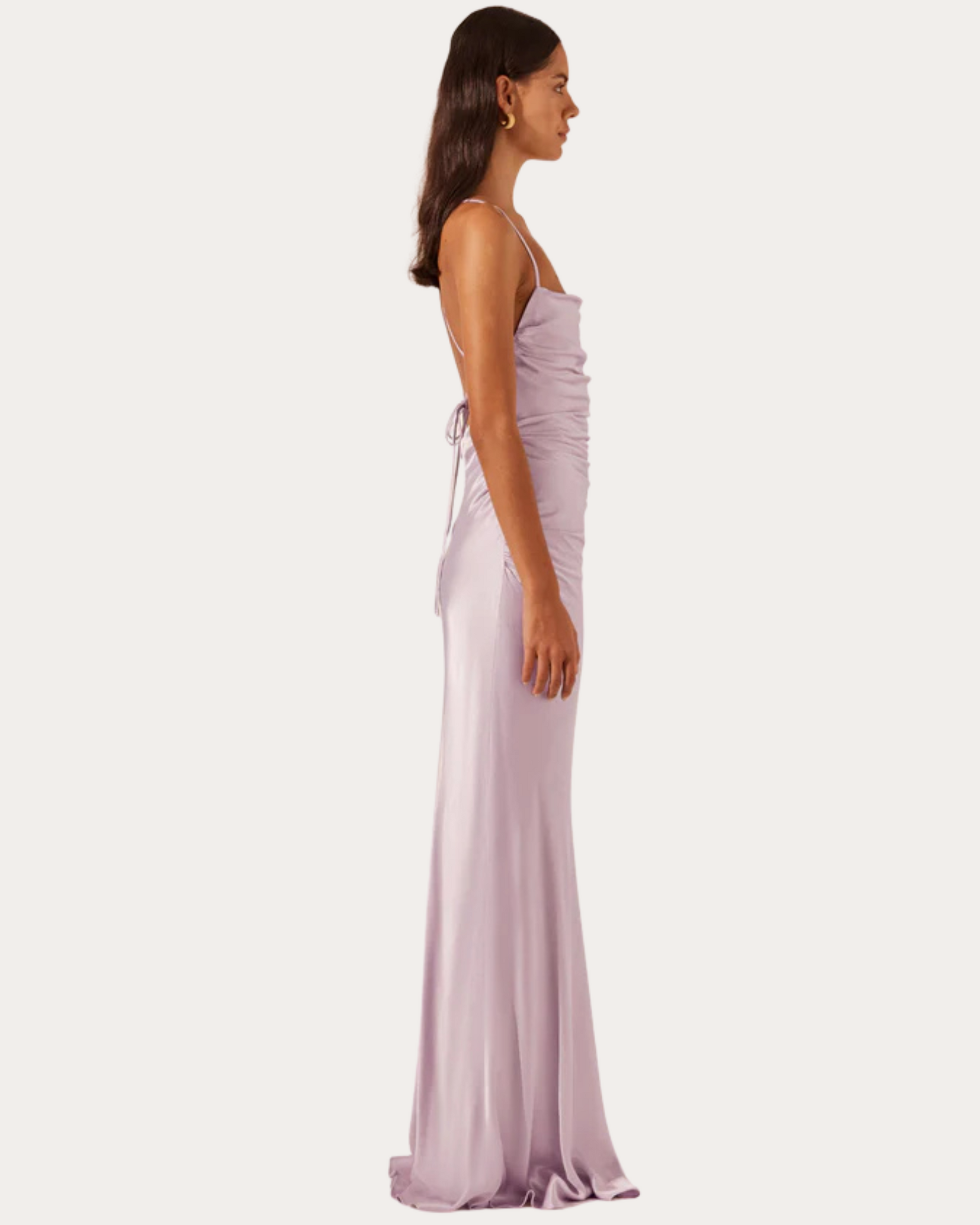 Profile shot of model in lilac La Lune Cross Back Maxi Dress with side ruching and flowing hemline, highlighting the dress's soft drape.