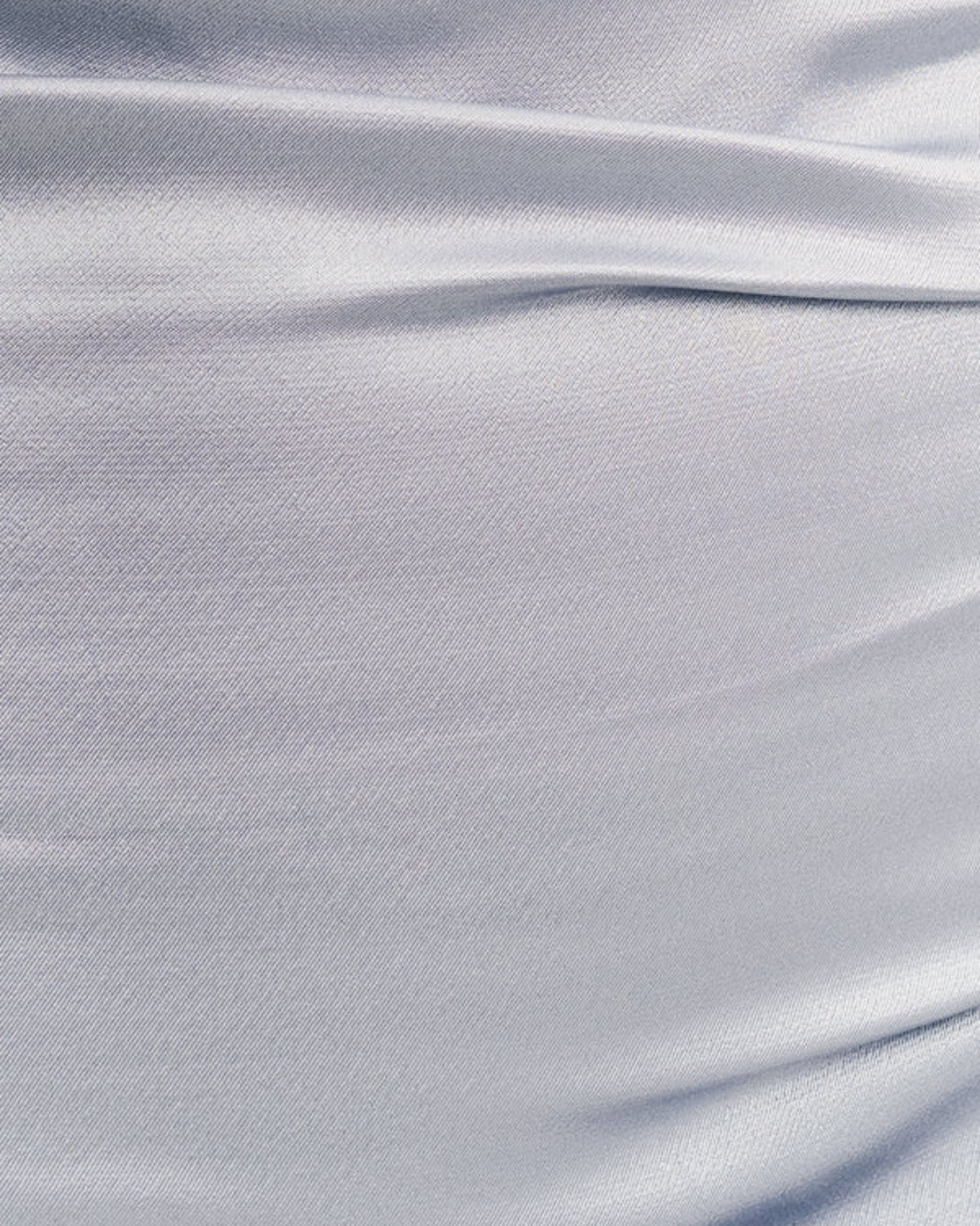 Close-up of the soft satin powder blue fabric from the La Lune One-Shoulder Dress, showing delicate ruching, available at Georgette Bridal in Brussels.