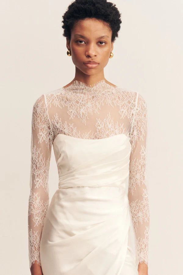Front view of the Lambent Lace Long Sleeve Bridal Bodysuit with intricate lace detailing and a high neckline, offering a timeless and sophisticated bridal look. Available at Georgette bridal boutique in Brussels and online at georgettebridal.com.