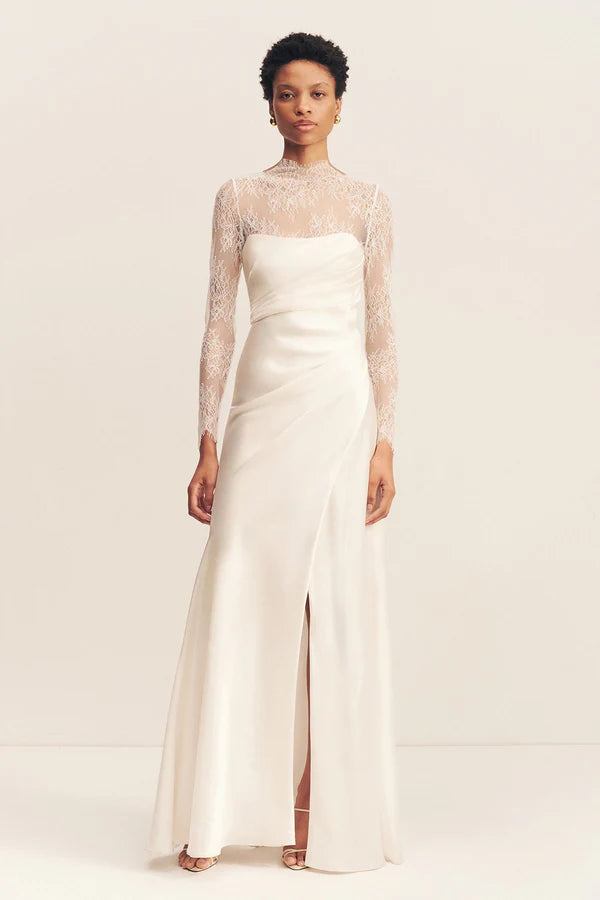 Model wearing the Lambent Lace Long Sleeve Bridal Bodysuit with intricate lace detailing and a high neckline, offering a timeless and sophisticated bridal look. Available at Georgette bridal boutique in Brussels and online at georgettebridal.com.