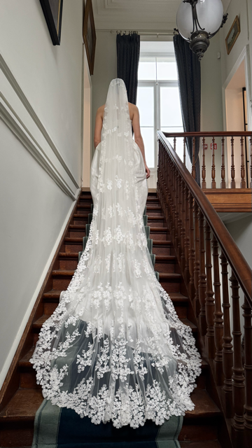 Long ivory veil with floral details and flowing silhouette, available at Georgette bridal boutique in Brussels and online at georgettebridal.com