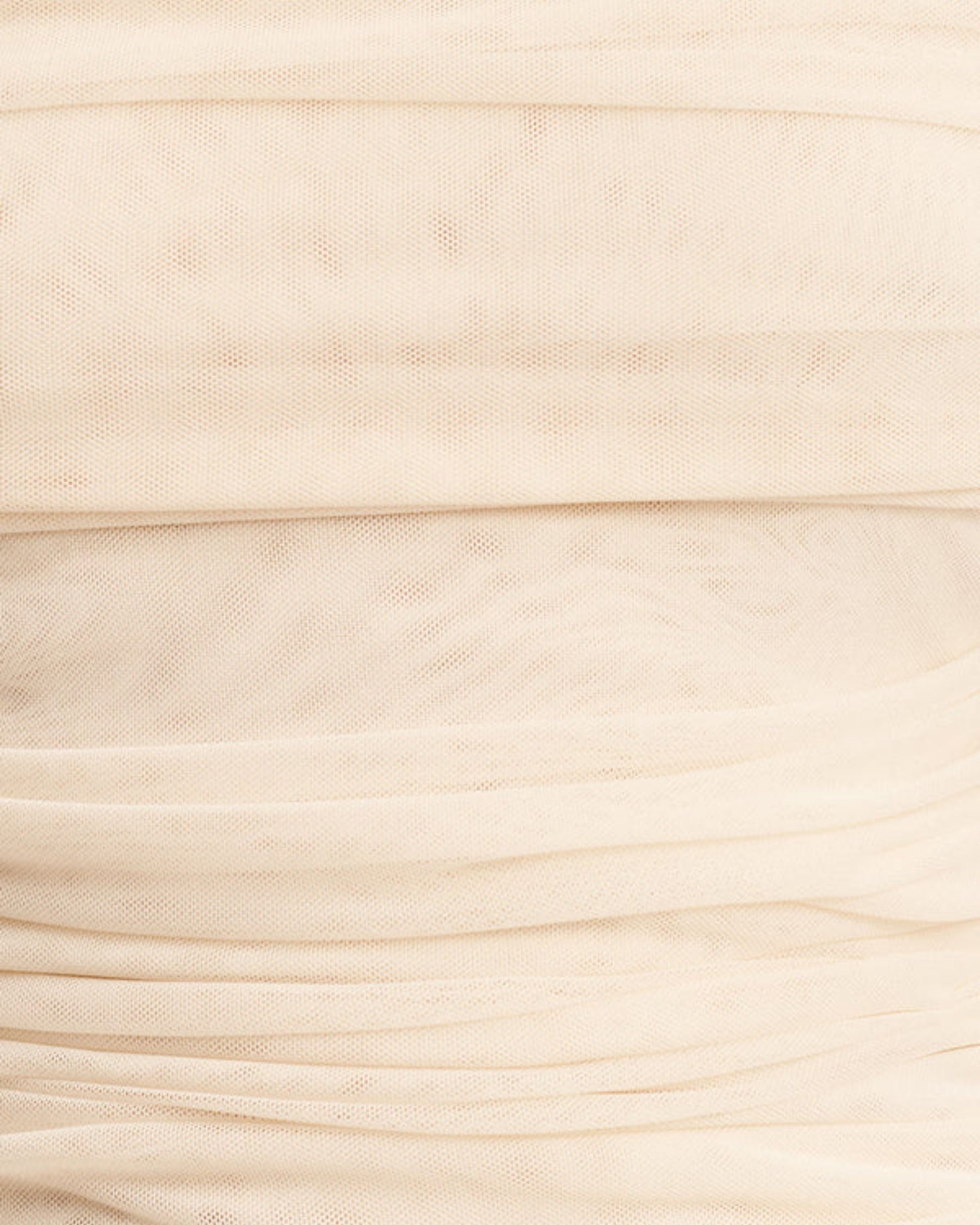 Fabric focus of Mira Long Sleeve Off Shoulder Top in ivory - a sheer mesh top with an off-shoulder neckline, long sleeves, and ruched side seams, creating a sculpted silhouette, available at Georgette bridal boutique in Brussels and online at georgettebridal.com.